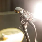 AUD premium large diaphragm studio condenser microphone mounted on boom arm in professional recording studio setup