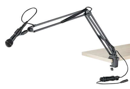 K&M microphone desk arm mounted on studio desk with microphone positioned for recording